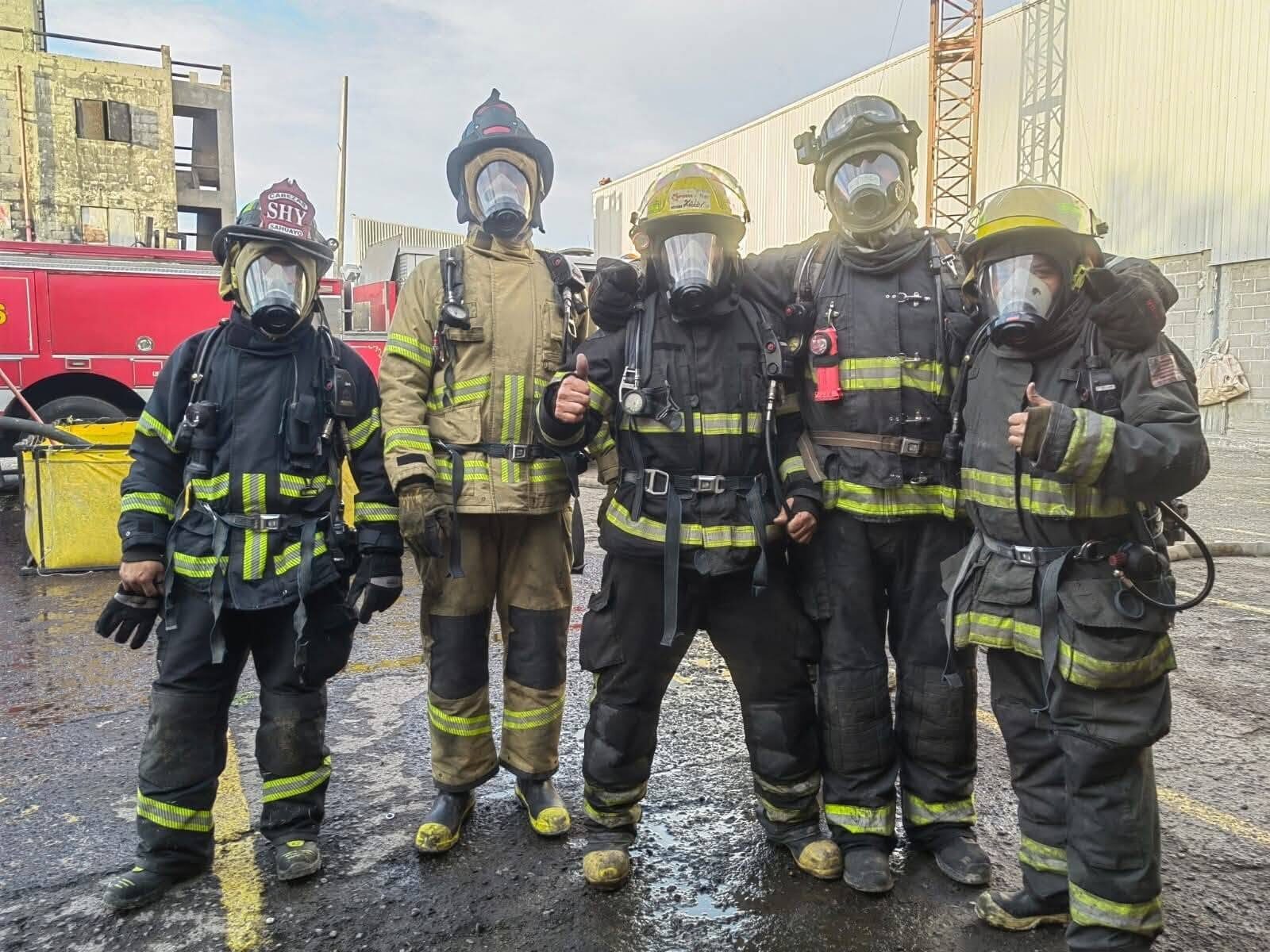 Bomberos de IAFFR con equipo de protección estructural y equipo autónomo de respiración durante una práctica