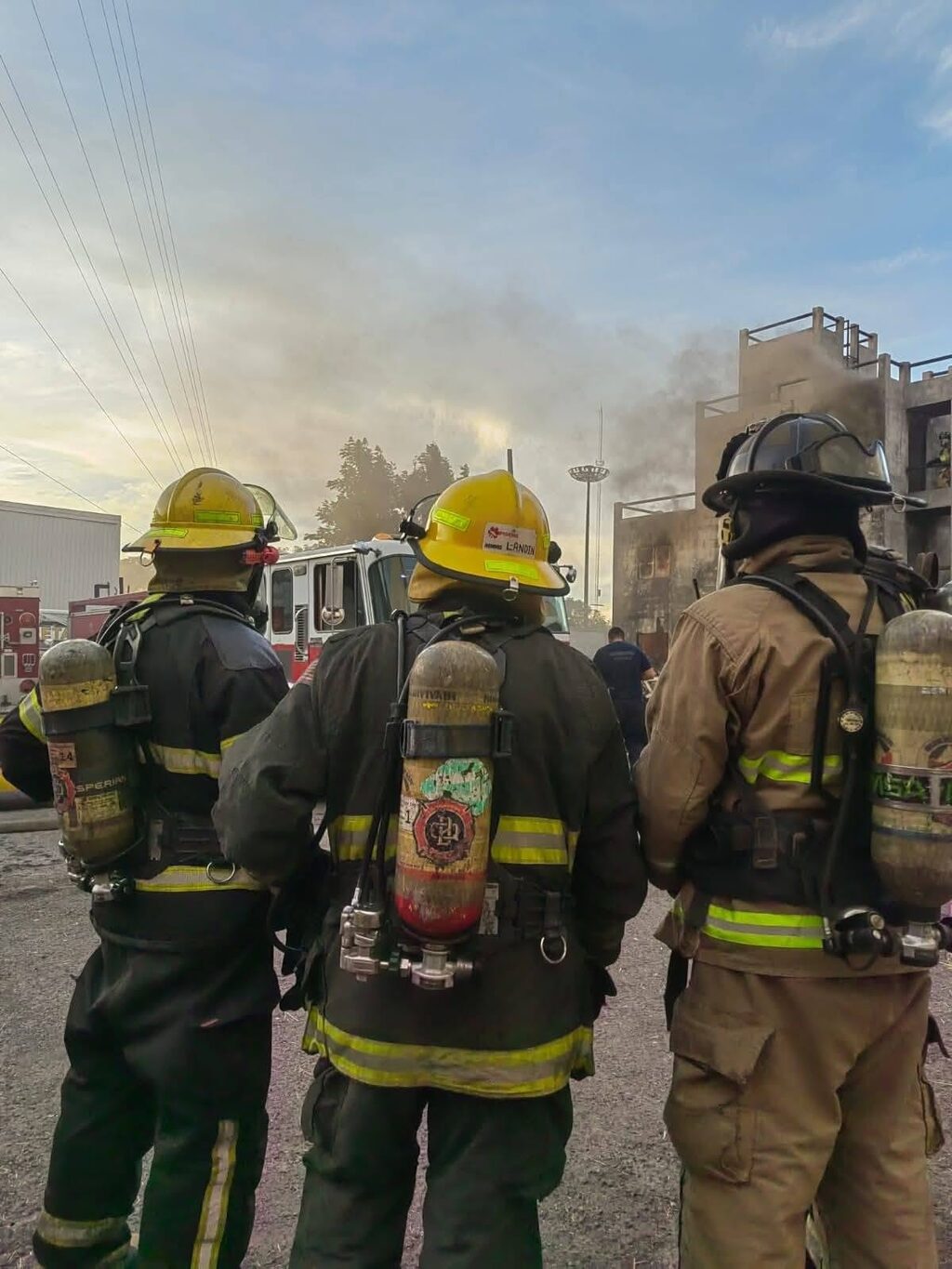 Bomberos de IAFFR frente al contenedor de entrenamiento durante una práctica con fuego real